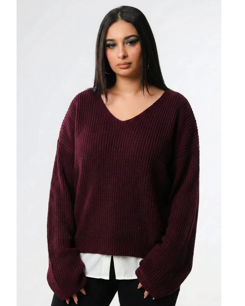 Woman wearing a burgundy sweater over a white shirt on a white background